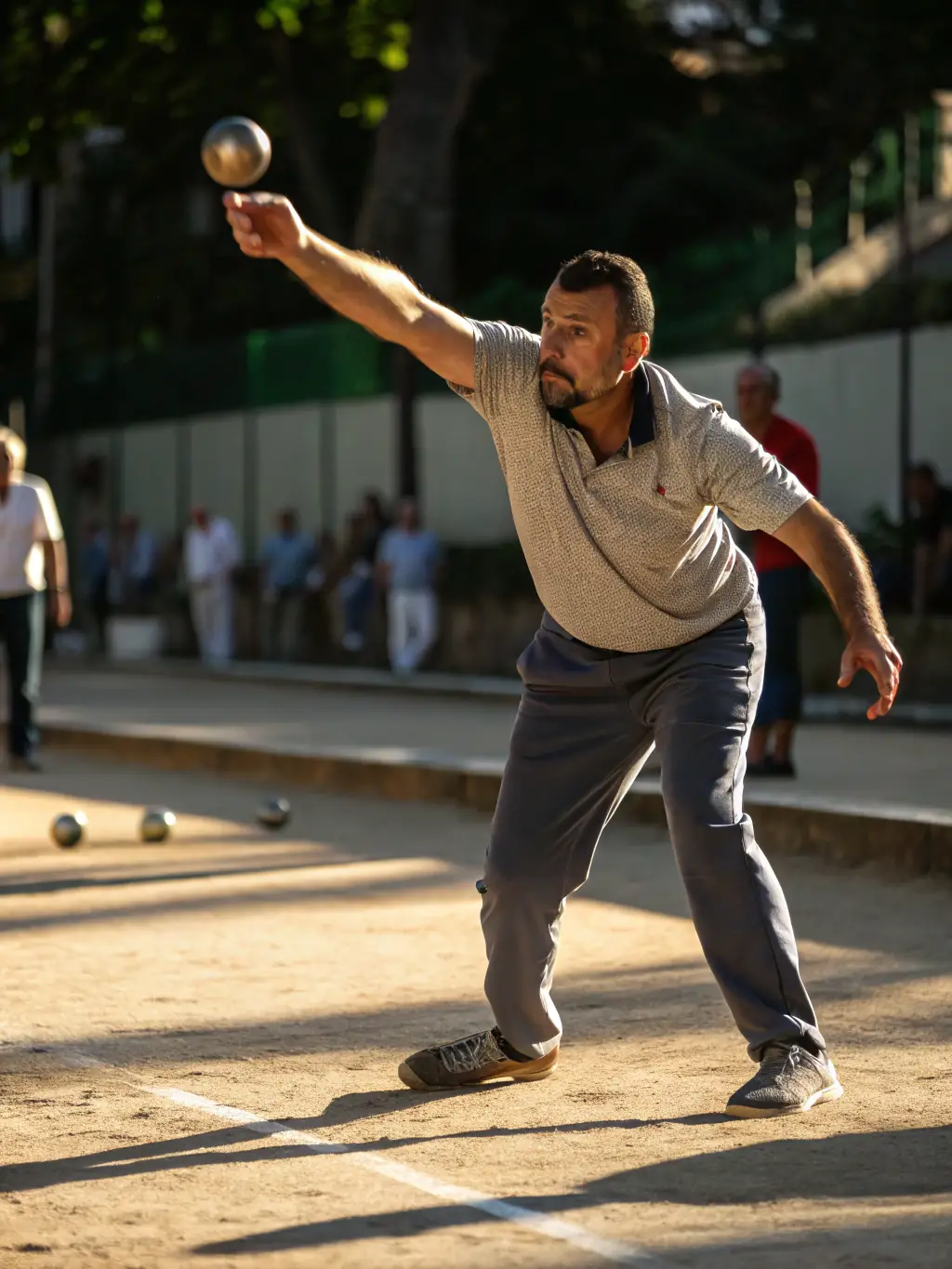 A close-up shot of a pétanque player's hand releasing a boule during a practice session at La Boule Roquefortoise, focusing on the precision and technique involved.